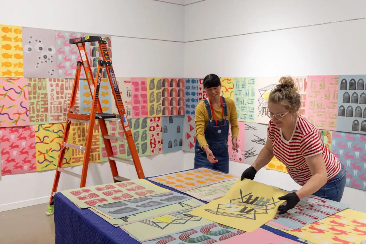 Artist Marlene Yuen and Preparator Jessie McNeil install Yuen's work