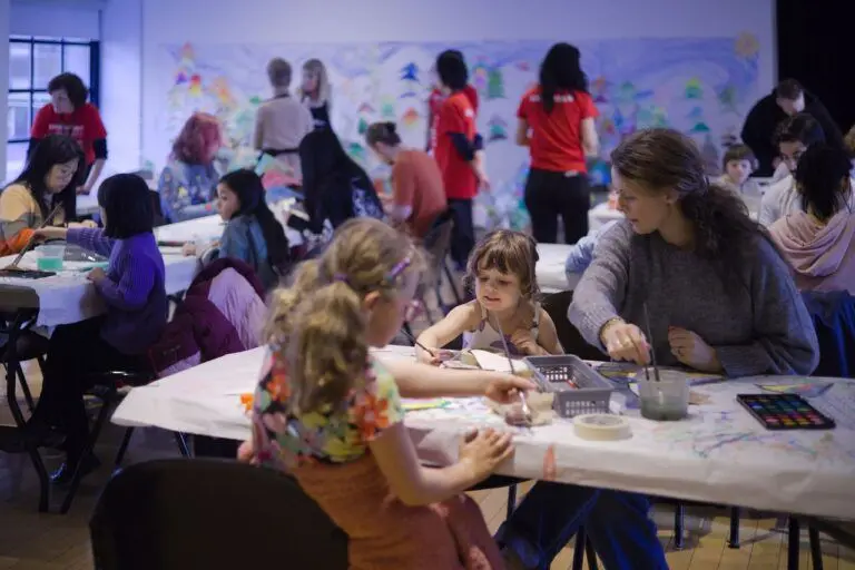 A room of families and people of all ages engaged in art-making activities at The Making Place.