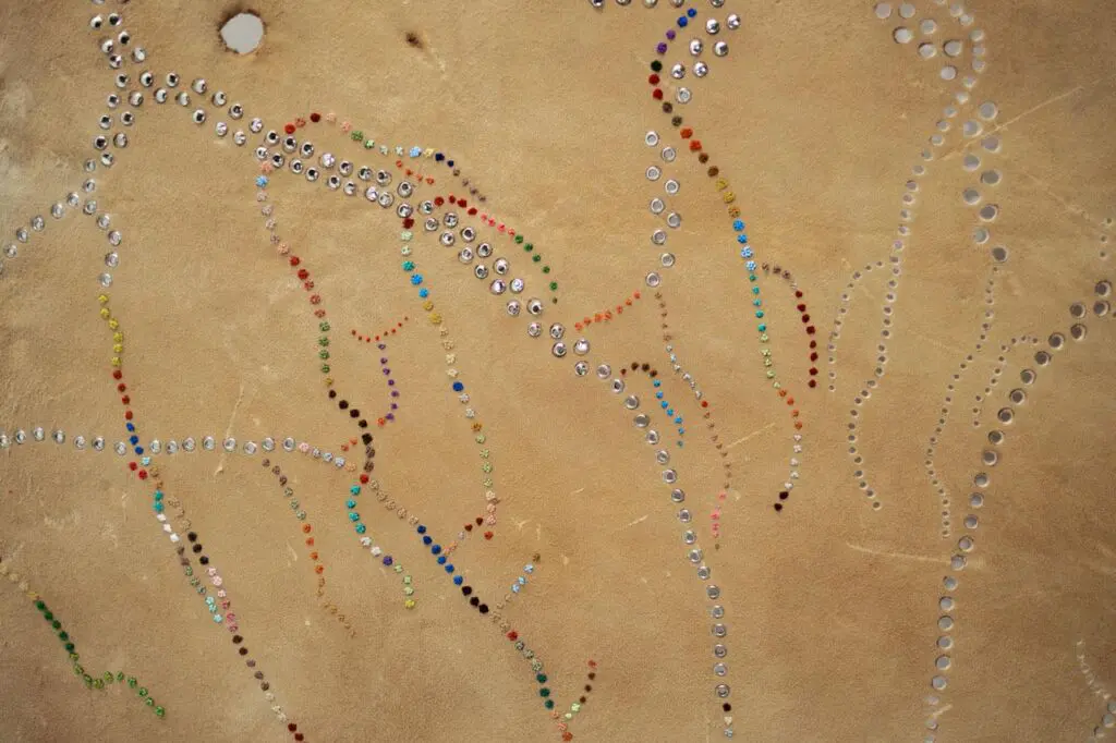 Detail look at deer with colourful thread sewn into it.