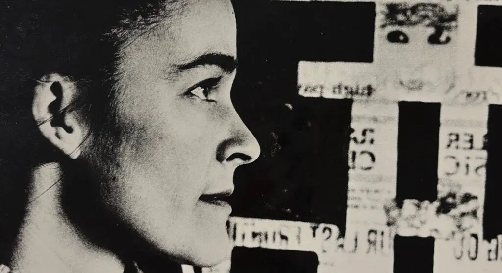 Side profile of a woman in black and white with artwork in the background