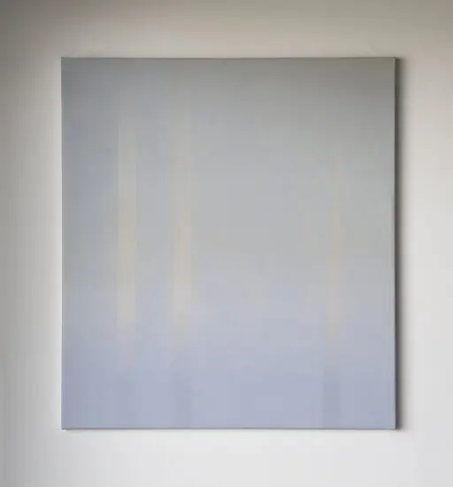 An image of a rectangular canvas on a white wall. The canvas is painted in a soft bluey purple colour, reminiscent of the sky.