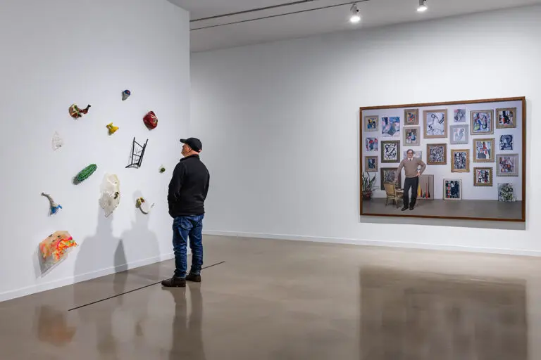 A man looks at an artwork by Jerry Pethick with Rodney Graham photograph in the background in the exhibition Postcards from the Heart.