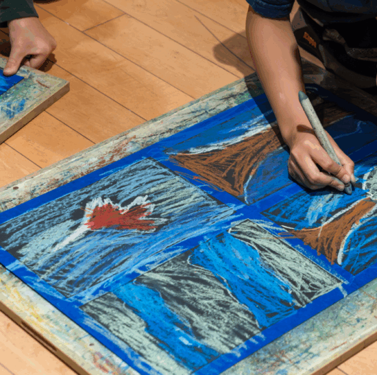 A detail photograph of children drawing trees inspired by Emily Carr in pastel