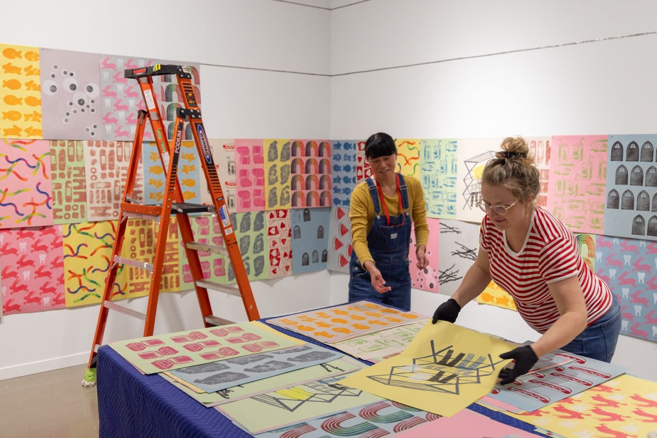 Artist Marlene Yuen and Preparator Jessie McNeil install Yuen's work
