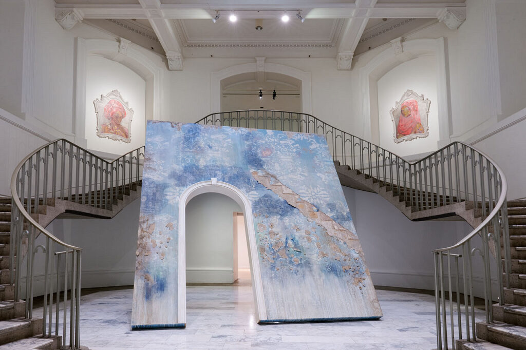 A large sculptural installation of a portal with an open doorway by artist Firelei Báez.