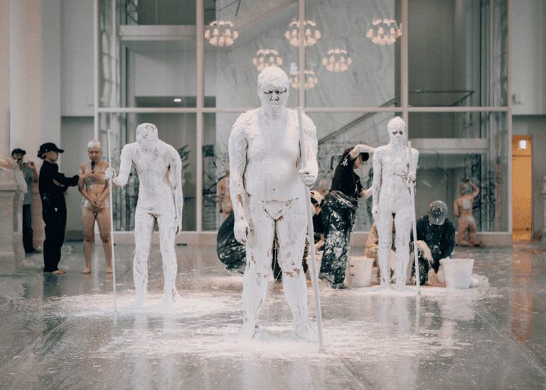 Figures are covered in white plaster as part of a performance by artist Tadasu Takamine.