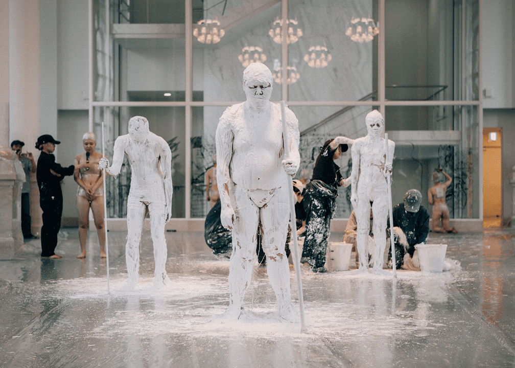 Performers are covered in plaster as part of the performance Sculptural Rebirth by Tadasu Takamine
