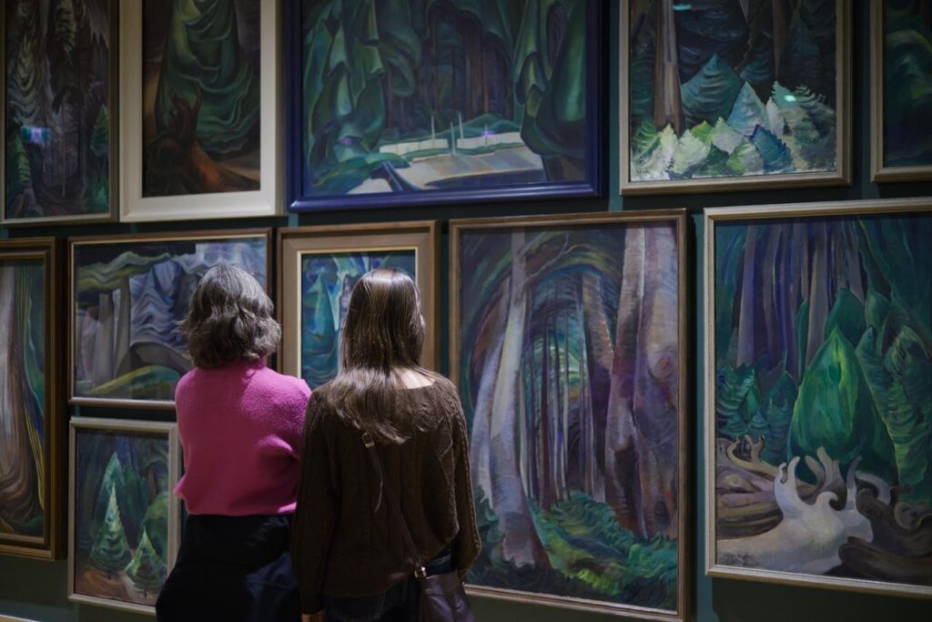 A mother and daughter look at the work of Emily Carr