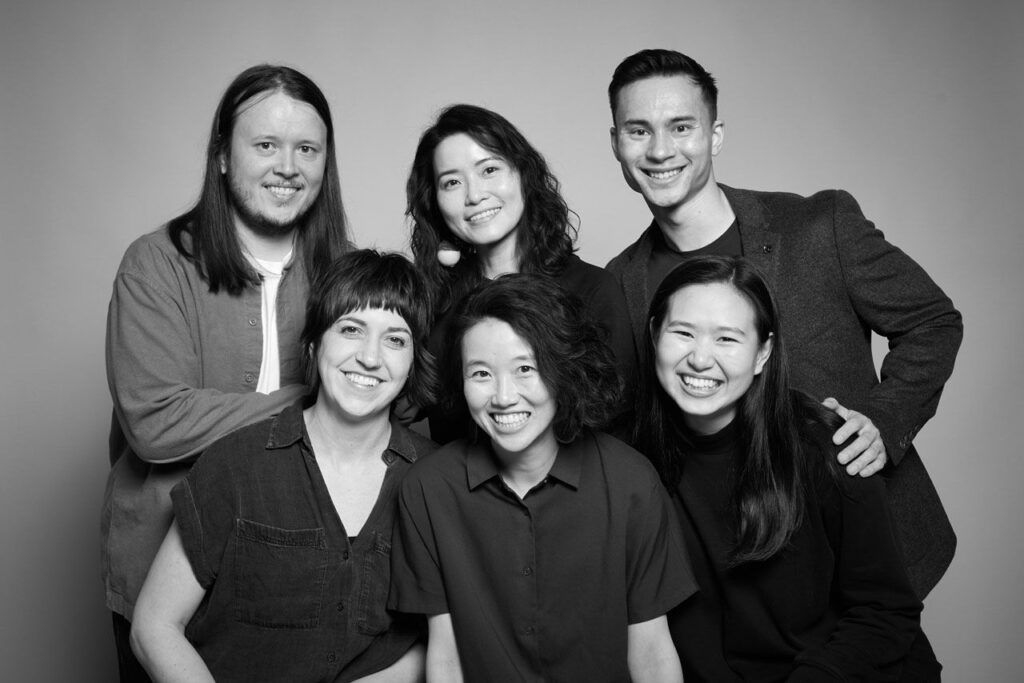 Group portrait in black and white of performers in Hong Kong Exile