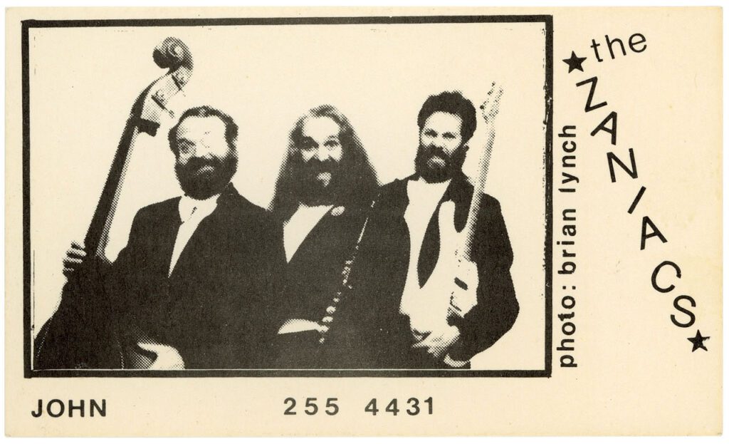 Business card for the band the Zaniacs featuring a black-and-white image of  3 men with instruments.