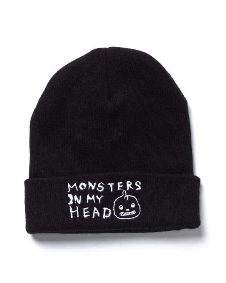 From of a black toque with English text in white "Monsters in My Head" and the Tanilla monster figure's head.