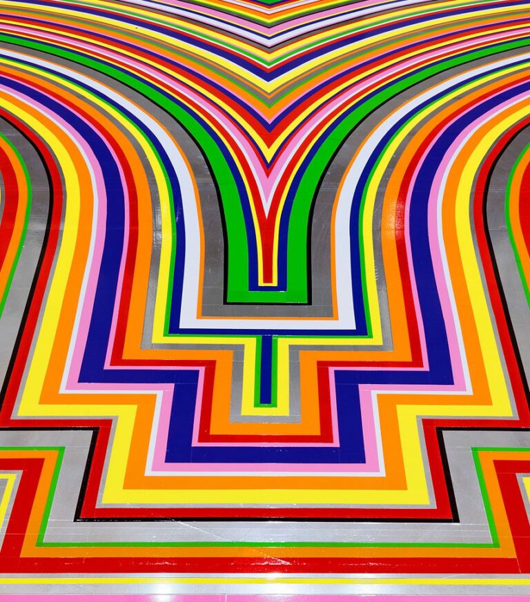 A detail photograph of Jim Lambie's artwork on the Gallery Rotunda's floor. The shot is looking at a detail of the floor covered in brightly coloured strips of vinyl in purple, pink, green, red, orange and yellow.