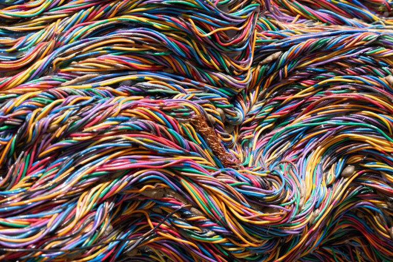 A photographic detail of an artwork by Emily Hermant made up of colourful telecommunication wires.