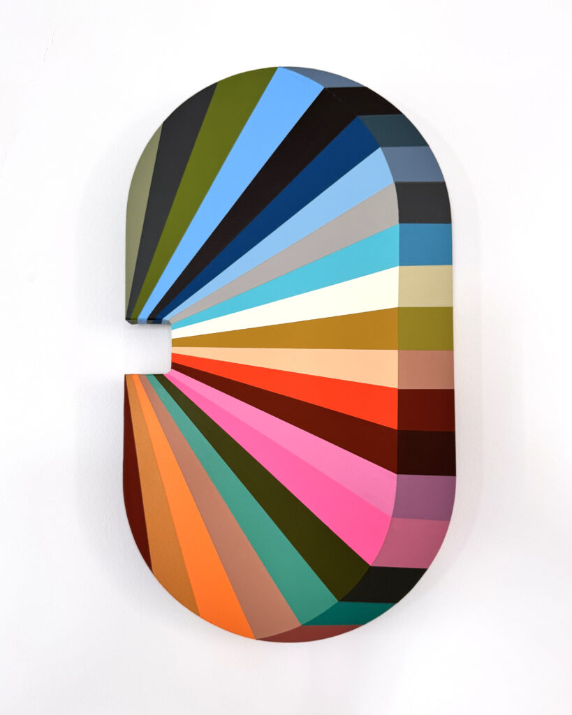 A photograph of an oval looking artworking with rays of colours on it.